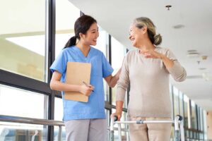 Resident choosing clothing with a caregiver in a bright assisted living apartment.